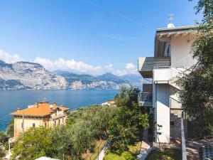 a building with a view of the water and mountains at Apartment La Maison Blanche-1 by Interhome in Brenzone sul Garda