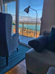 a living room with a couch and a view of the ocean at Villa Borostyán in Tihany