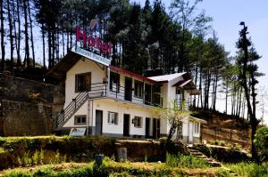 a white building with a sign on top of it at Hotel Mount Paradise in Nagarkot