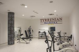 un gimnasio con cintas de correr y equipos de ejercicio y un cartel en Park Hotel Tyrrenian, en Amantea