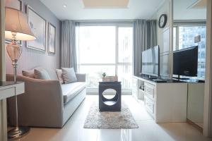 ein Wohnzimmer mit Couch und Fernseher in der Unterkunft Classica by Kozystay - Kuningan in Jakarta