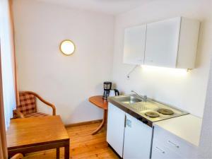 een kleine keuken met een wastafel en een tafel bij Apartment Flesch-3 by Interhome in Schelingen