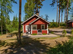 a red and white shed in the woods at Holiday Home Sepelkyyhky by Interhome in Hirsjärvi