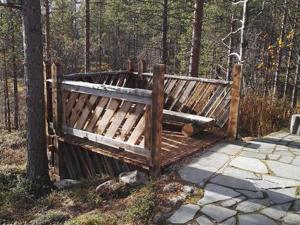 un banco de madera sentado junto a un árbol en Holiday Home Kuukkelitupa by Interhome, en Vuontisjärvi