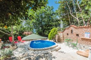 a backyard with a swimming pool and a brick wall at Apartments Borik Crikvenica in Crikvenica