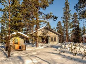 a log cabin in the snow with trees at Holiday Home Visapirtti by Interhome in Ivalo
