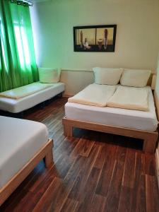 twee bedden in een kamer met groene gordijnen bij Oase Residence in Stuttgart