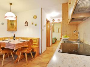 cocina con mesa con sillas y fregadero en Apartment Monti Pallidi by Interhome en Campitello di Fassa