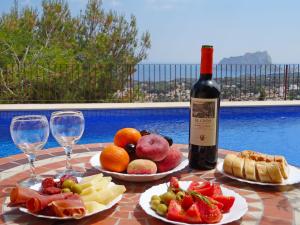una mesa con platos de fruta y una botella de vino en Holiday Home Villa Osyris by Interhome, en Fanadix