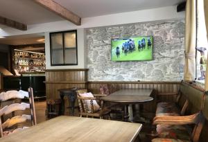 a restaurant with tables and a tv on the wall at The Lion at Malpas in Malpas