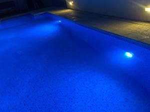 una piscina con luces azules en una habitación en Casa con Gran Piscina particular cerca playa, en Torredembarra