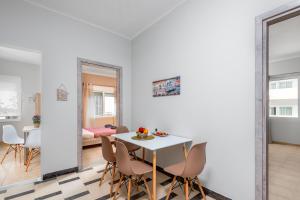 een witte eetkamer met een witte tafel en stoelen bij TownHall Apartment's in Rhodos-stad