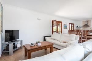 salon z białą kanapą i telewizorem w obiekcie Villa Pou d,Ambroitx, pool and sea views in Alcudia w Alcudii