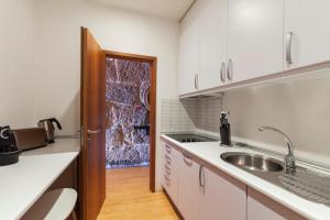 une cuisine avec des armoires blanches et un évier dans l'établissement Go2oporto - Ribeira do Porto, à Porto 38 autres photos