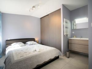 a bedroom with a bed and a sink and a tub at Holiday Home Villa du Littoral by Interhome in Le Grau-dʼAgde