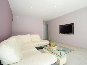a white living room with a white couch and a tv at Holiday Home Villa du Littoral by Interhome in Le Grau-dʼAgde