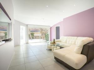a living room with a couch and a table at Holiday Home Villa du Littoral by Interhome in Le Grau-dʼAgde