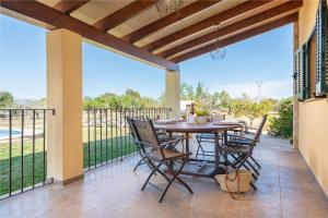 patio ze stołem, krzesłami i ogrodzeniem w obiekcie Villa Pou d,Ambroitx, pool and sea views in Alcudia w Alcudii