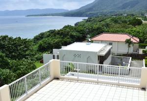 a balcony of a house with a view of the ocean at Kasane / The Family Villa in Ishigaki Island