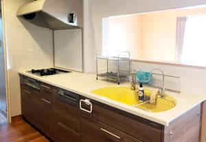 a kitchen with a yellow sink and a stove at Kasane / The Family Villa in Ishigaki Island +17 photos