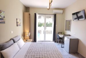 1 dormitorio con cama, escritorio y ventana en Achillion Hotel Piraeus, en Pireo