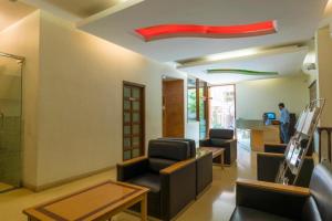 a waiting room with chairs and tables and a red ceiling at Crescent Park in Chennai