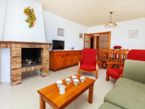 ein Wohnzimmer mit einem Kamin und einem Tisch in der Unterkunft Holiday Home Torre Mora-4 by Interhome in Pals