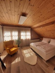 1 dormitorio con 1 cama y 1 silla en Ferienwohnung "Marie's Auszeit" en Bodensdorf