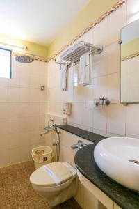 a bathroom with a toilet and a sink at Crescent Park in Chennai +8 photos