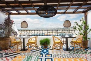 d'un patio avec des tables et des chaises et une vue. dans l'établissement Hotel La Torre del Canonigo - Small Luxury Hotels, à Ibiza