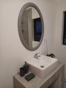 une salle de bain avec un lavabo blanc et un miroir dans l'établissement @Oudam, à Montagu 23 autres photos