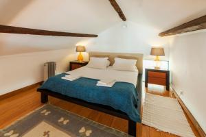 um quarto com uma cama e duas mesas de cabeceira e dois candeeiros em Go2oporto - Ribeira do Porto em Porto