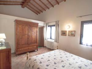 een slaapkamer met een bed en een houten kast bij Villa Il Circolo by Interhome in Borselli