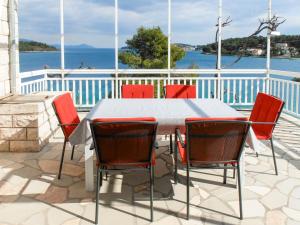 a table and chairs on a patio with the water at Holiday Home Bernardi by Interhome in Lumbarda