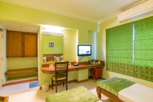 Habitación con 1 dormitorio con escritorio y TV. en Crescent Park en Chennai
