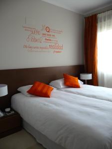 two beds with orange pillows in a hotel room at Villa in Spain at Las Colinas Golf & Country Club in Orihuela Costa