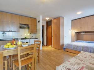 kuchnia oraz pokój ze stołem i łóżkiem w obiekcie Studio Apt 14 by Interhome w mieście Alba di Canazei