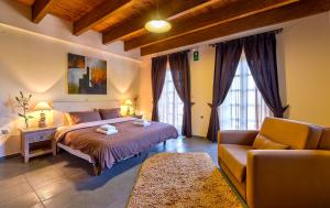 a bedroom with a large bed and a couch at Apirathes Residence in Zoúrva +53 photos