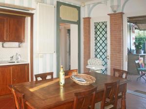 a dining room table with a bottle of wine on it at Villa Lorenzo by Interhome in Forte dei Marmi