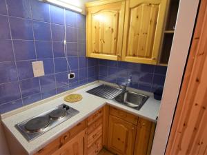 a kitchen with wooden cabinets and a sink at Studio Apt 8 by Interhome in Alba di Canazei