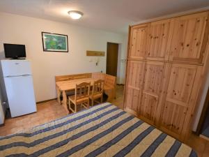 a bedroom with a bed and a table and a refrigerator at Studio Apt 8 by Interhome in Alba di Canazei