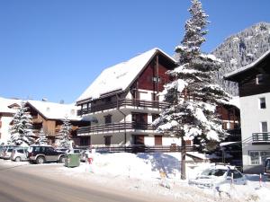 ein großes Gebäude mit einem schneebedeckten Dach in der Unterkunft Studio Marmolada-2 by Interhome in Alba di Canazei