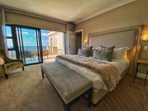 um quarto com uma cama grande e uma varanda em The Northcliff Boutique Hotel em Joanesburgo