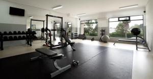 a gym with several treadmills and machines and windows at Estrela do Vau Mariosilvat in Portimão