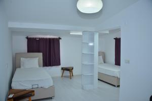 een kleine kamer met 2 bedden en een lamp bij Aquarius Hotel in Side
