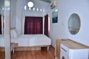 西代的住宿－Aquarius Hotel，卧室配有白色的床和镜子