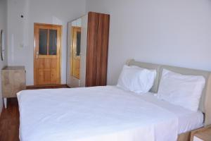a bedroom with a white bed and a wooden door at Aquarius Hotel in Side