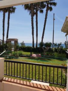 einen Balkon mit Palmen und Meerblick in der Unterkunft Laguna Beach in Torrox Costa