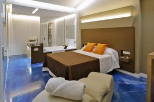 ein Hotelzimmer mit einem Bett und einer Badewanne in der Unterkunft Motel Latino in Llanera