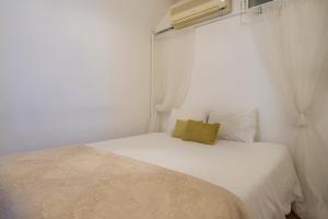 a small bedroom with a white bed and a window at Romantic Apartment + Tejo River View in Lisbon